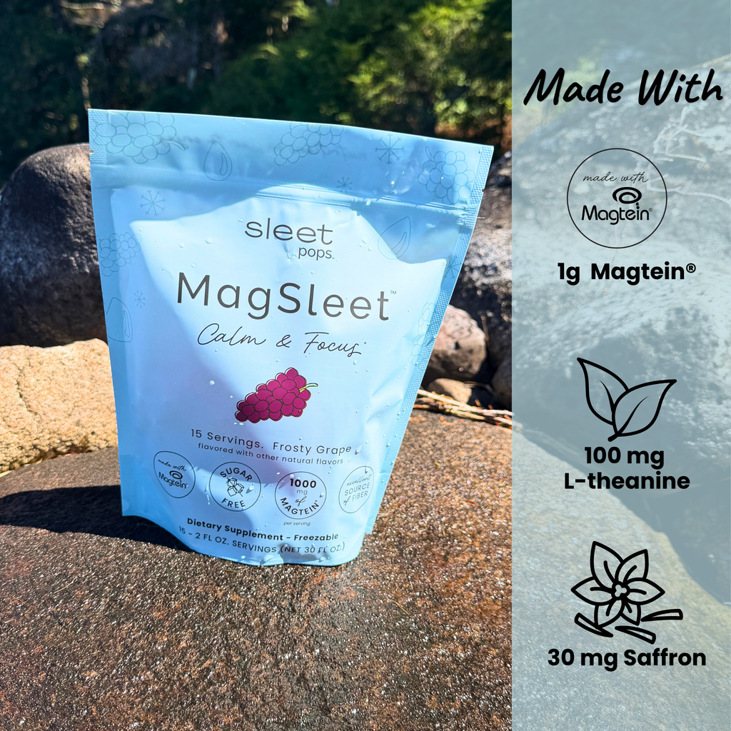 A stand-up pouch of Sleet Pops MagSleet Calm & Focus dietary supplement stands outdoors on a rock, with a vertical informational panel on the right highlighting Made With Magtein, 1g Magtein, 100 mg L-theanine, and 30 mg Saffron.