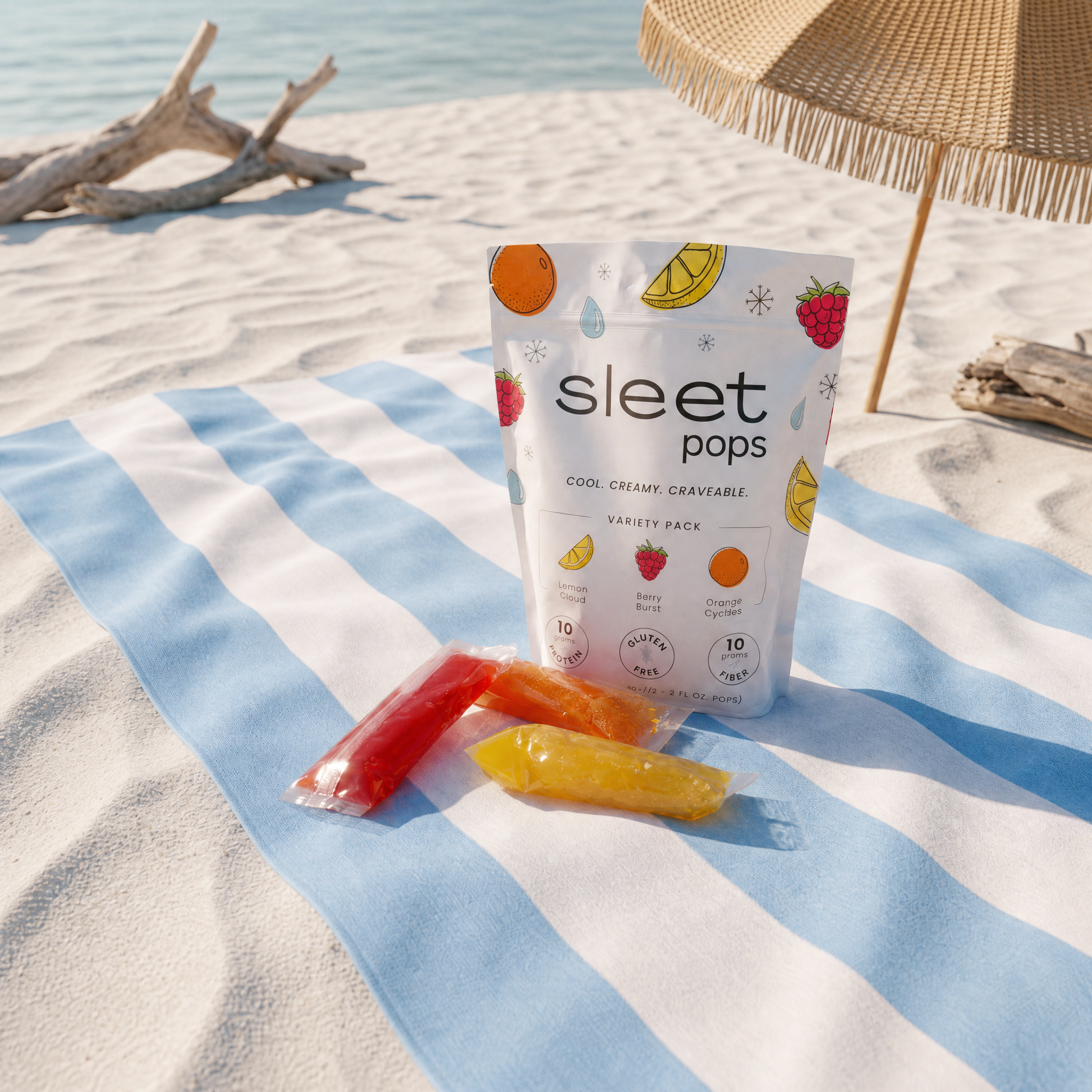 Sleet Pops packaging on a beach with colorful popsicles and an umbrella in the background.